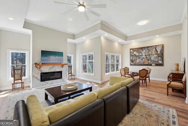 living area with baseboards, ceiling fan, recessed lighting, light wood-style flooring, and a fireplace