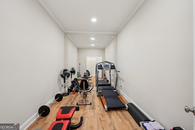 exercise area with crown molding, baseboards, and wood finished floors