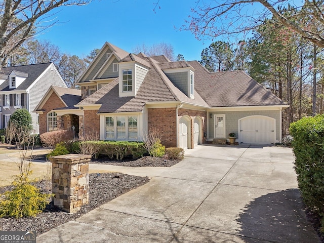 view of front of property with brick siding, an attached garage, concrete driveway, and a shingled roof