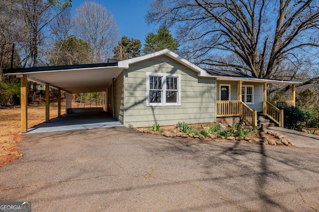 view of front of home with aphalt driveway, covered porch, and an attached carport