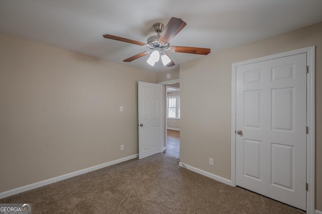 unfurnished bedroom featuring carpet flooring, a ceiling fan, and baseboards