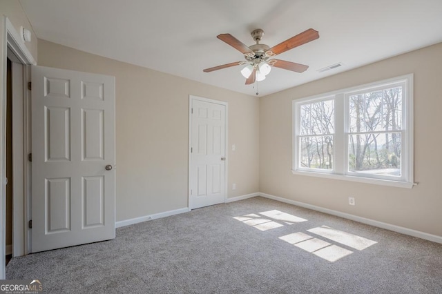 unfurnished bedroom featuring visible vents, carpet flooring, a ceiling fan, and baseboards