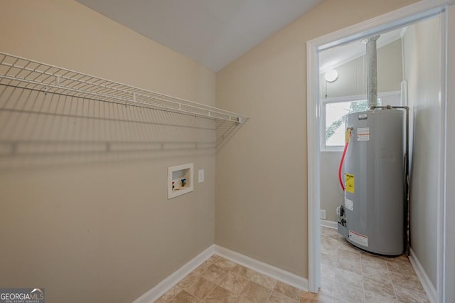 laundry area featuring baseboards, washer hookup, laundry area, and water heater