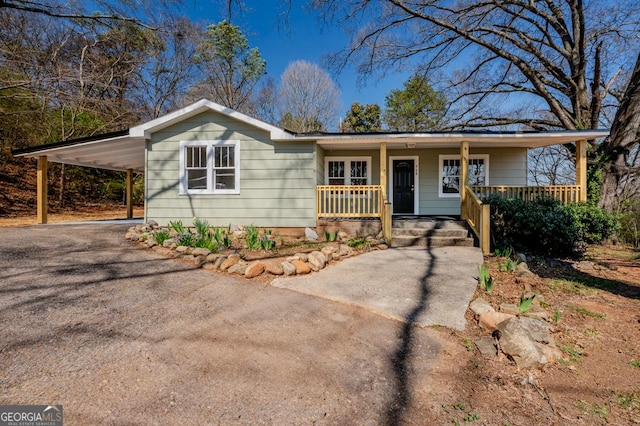 ranch-style house with aphalt driveway, a porch, and a carport