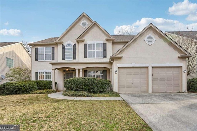 traditional-style home with stucco siding, a front yard, an attached garage, and driveway