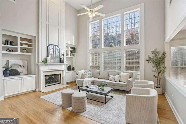 living area featuring a high ceiling, wood finished floors, and a ceiling fan