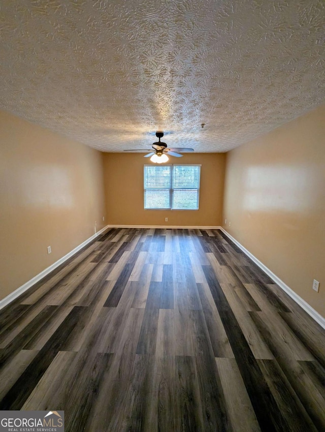 empty room featuring wood finished floors, a ceiling fan, and baseboards