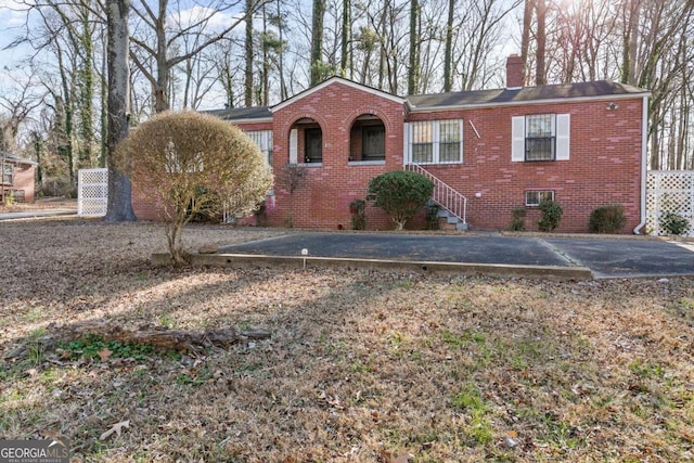 view of front facade featuring brick siding and a chimney