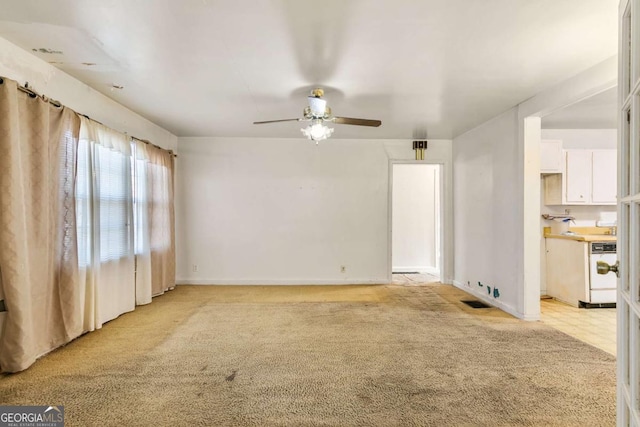 unfurnished living room featuring visible vents, light colored carpet, baseboards, and ceiling fan