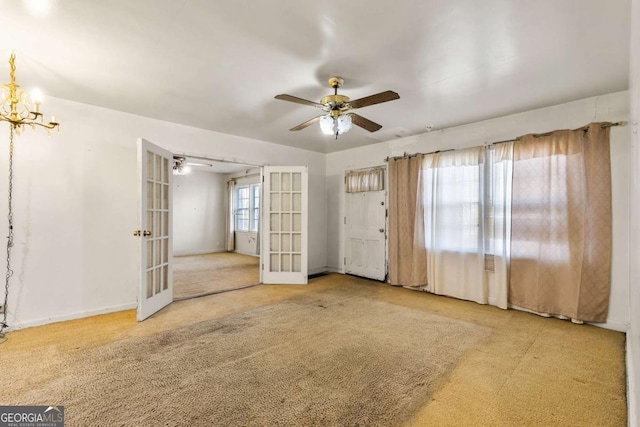 carpeted spare room featuring a ceiling fan, french doors, and baseboards