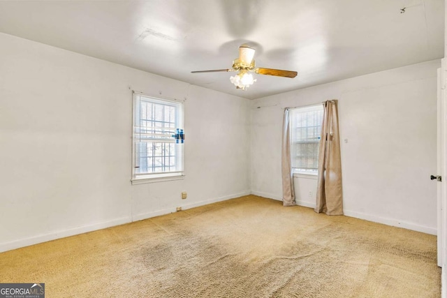 carpeted spare room with baseboards and a ceiling fan