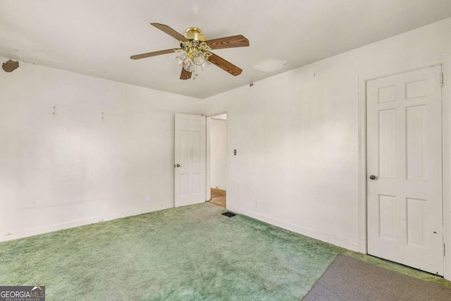 carpeted spare room featuring baseboards and ceiling fan