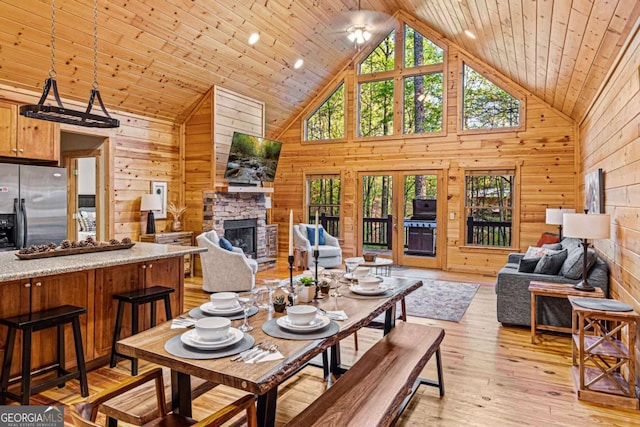 dining room with wooden walls, wood ceiling, and a fireplace