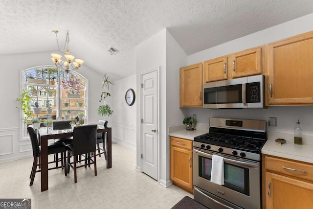 kitchen featuring visible vents, a notable chandelier, appliances with stainless steel finishes, light countertops, and lofted ceiling