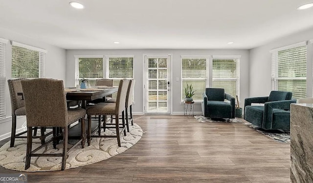 dining space with a wealth of natural light, recessed lighting, baseboards, and wood finished floors