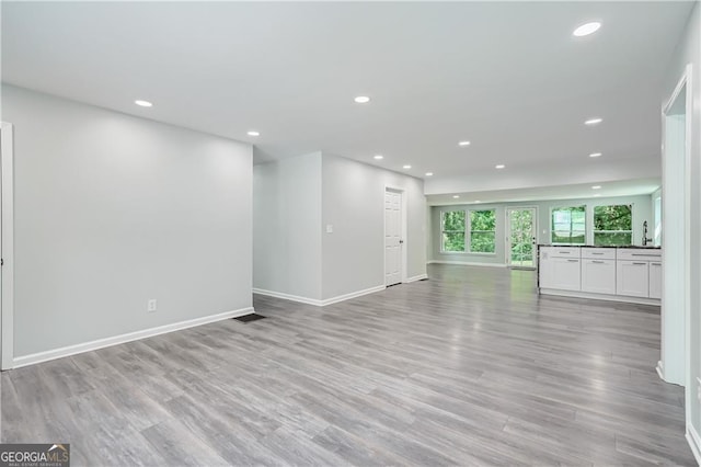 unfurnished living room with recessed lighting, visible vents, baseboards, and light wood-style floors