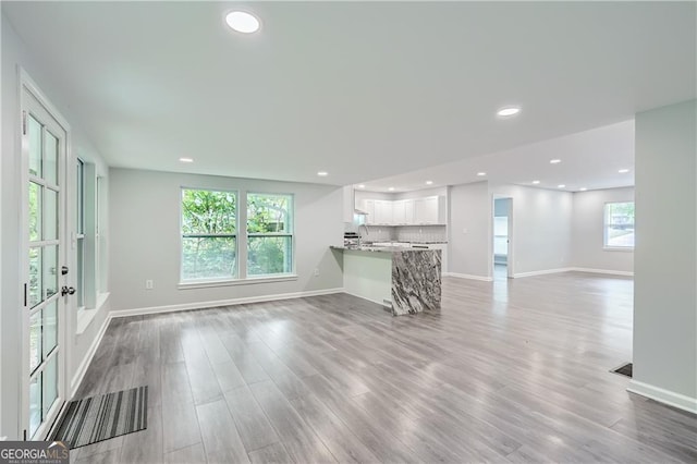 unfurnished living room with recessed lighting, baseboards, and wood finished floors