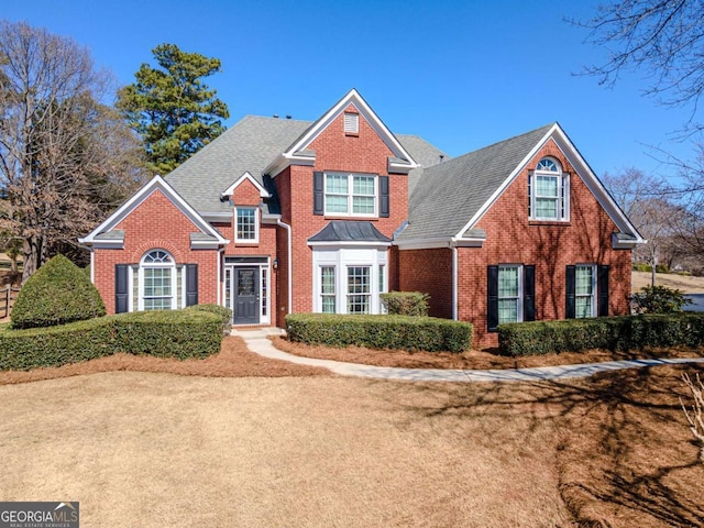 traditional-style home with brick siding and a shingled roof