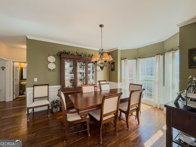 dining space featuring an inviting chandelier, wood finished floors, and ornamental molding