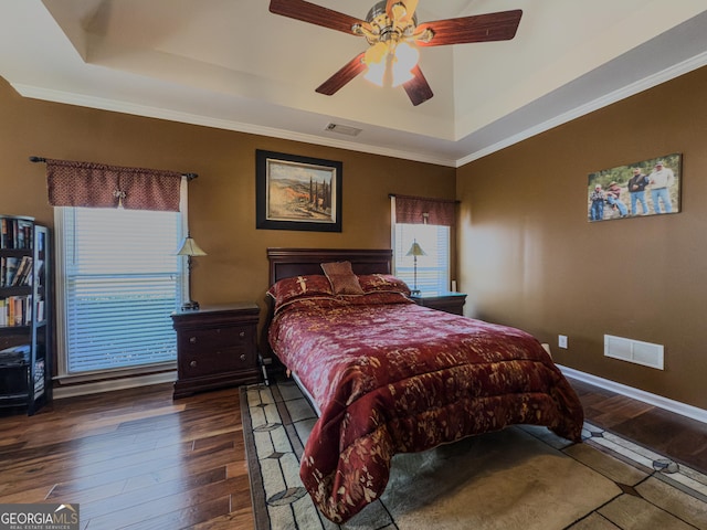 bedroom with visible vents, a raised ceiling, and hardwood / wood-style floors