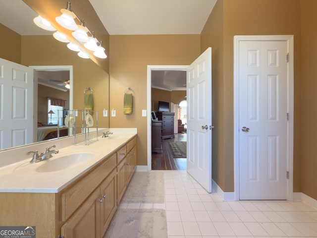 full bath featuring tile patterned floors, ensuite bathroom, ceiling fan, and a sink