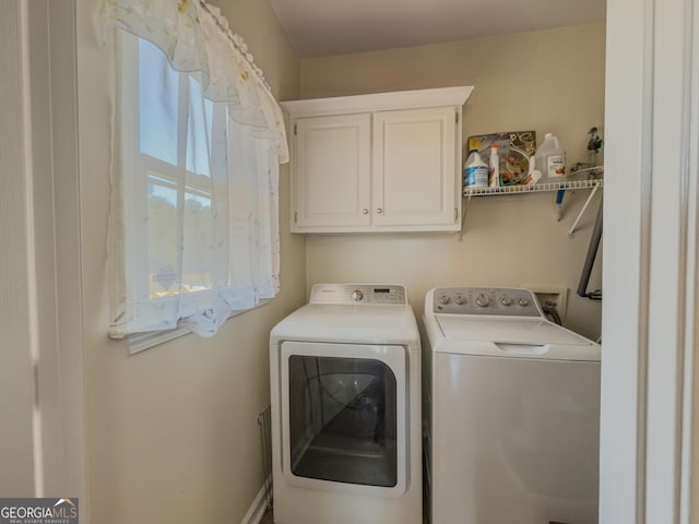 washroom featuring washing machine and clothes dryer and cabinet space