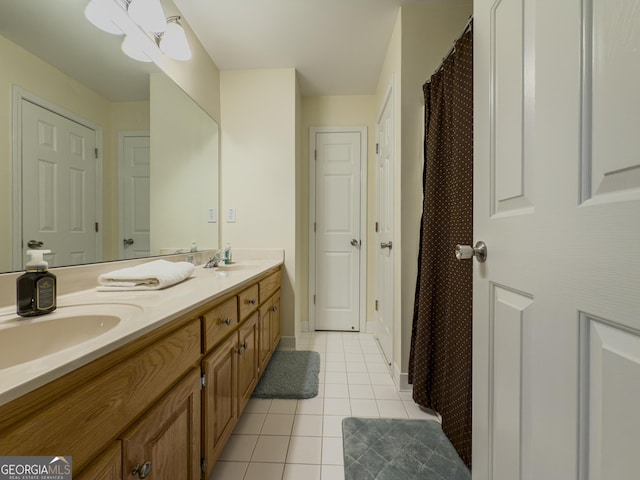 bathroom with tile patterned floors, double vanity, baseboards, and a sink