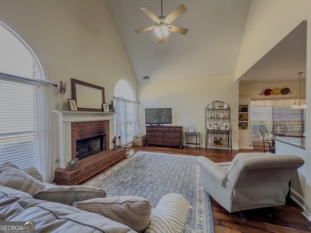 living room with visible vents, high vaulted ceiling, a ceiling fan, dark wood finished floors, and a fireplace