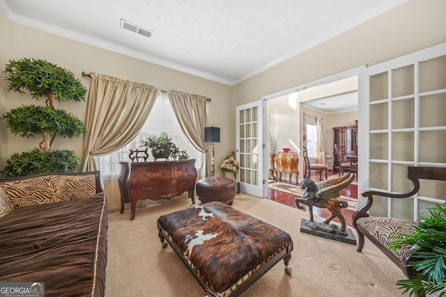 living area with visible vents, carpet floors, french doors, a textured ceiling, and crown molding