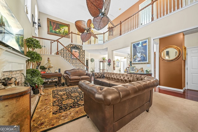 living room with stairs, plenty of natural light, and a ceiling fan