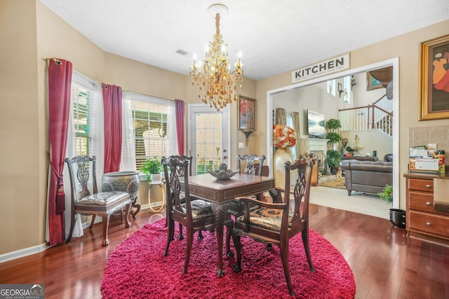 dining area with hardwood / wood-style floors, a notable chandelier, baseboards, and visible vents