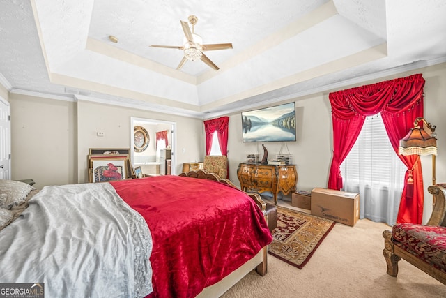 bedroom featuring a textured ceiling, carpet, a tray ceiling, and ornamental molding