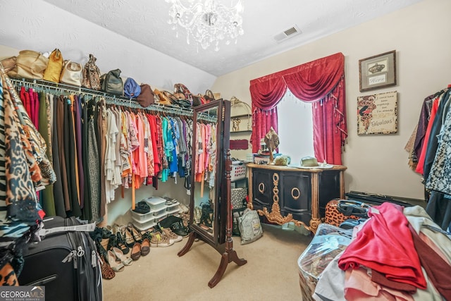 spacious closet with visible vents, an inviting chandelier, and carpet