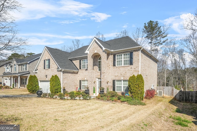 view of front of house with fence, an attached garage, a shingled roof, brick siding, and central AC unit