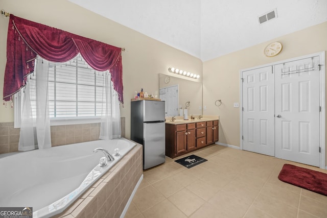 full bath featuring tile patterned floors, a bath, visible vents, and lofted ceiling