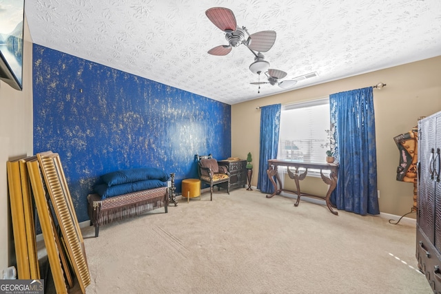 living area with visible vents, baseboards, ceiling fan, a textured ceiling, and carpet flooring