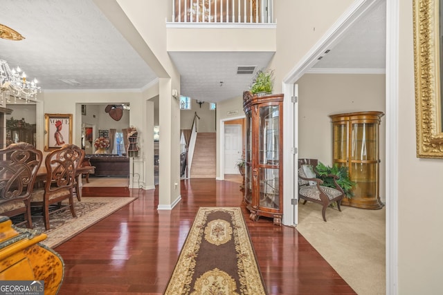 entryway featuring stairway, wood finished floors, ornamental molding, and a chandelier