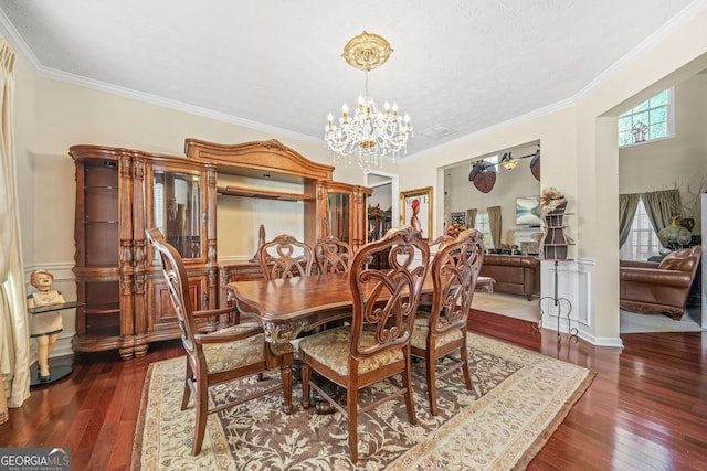 dining room featuring a chandelier, crown molding, and hardwood / wood-style flooring