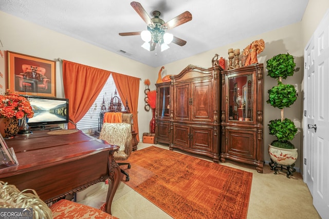 office featuring light carpet, visible vents, and ceiling fan