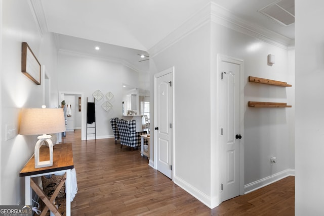 corridor with recessed lighting, lofted ceiling, wood finished floors, ornamental molding, and baseboards