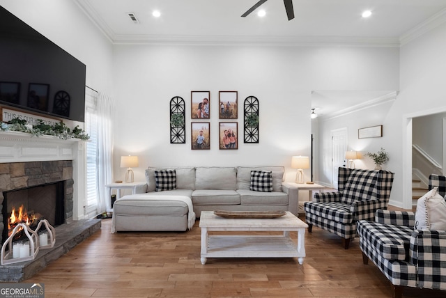 living area with visible vents, crown molding, and ceiling fan