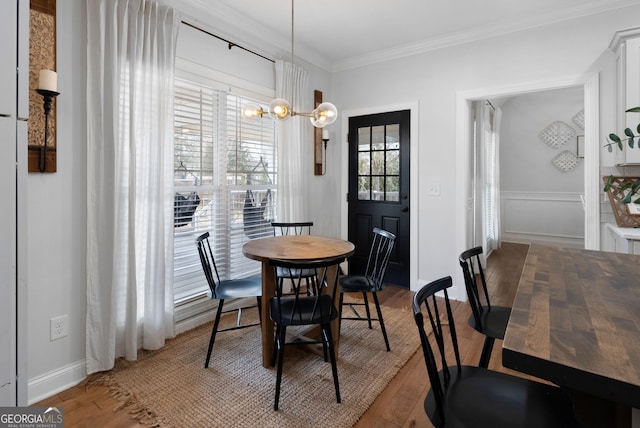 dining space featuring a chandelier, wood finished floors, and ornamental molding