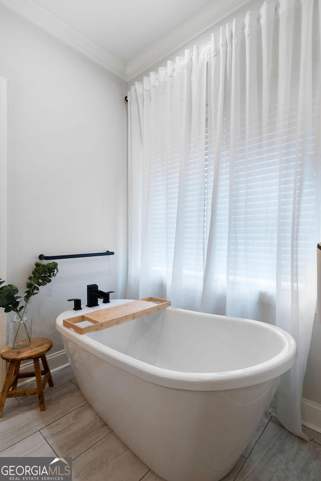bathroom featuring a freestanding bath and crown molding