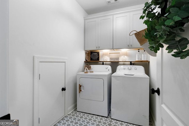 washroom with cabinet space, visible vents, washer and dryer, and light floors