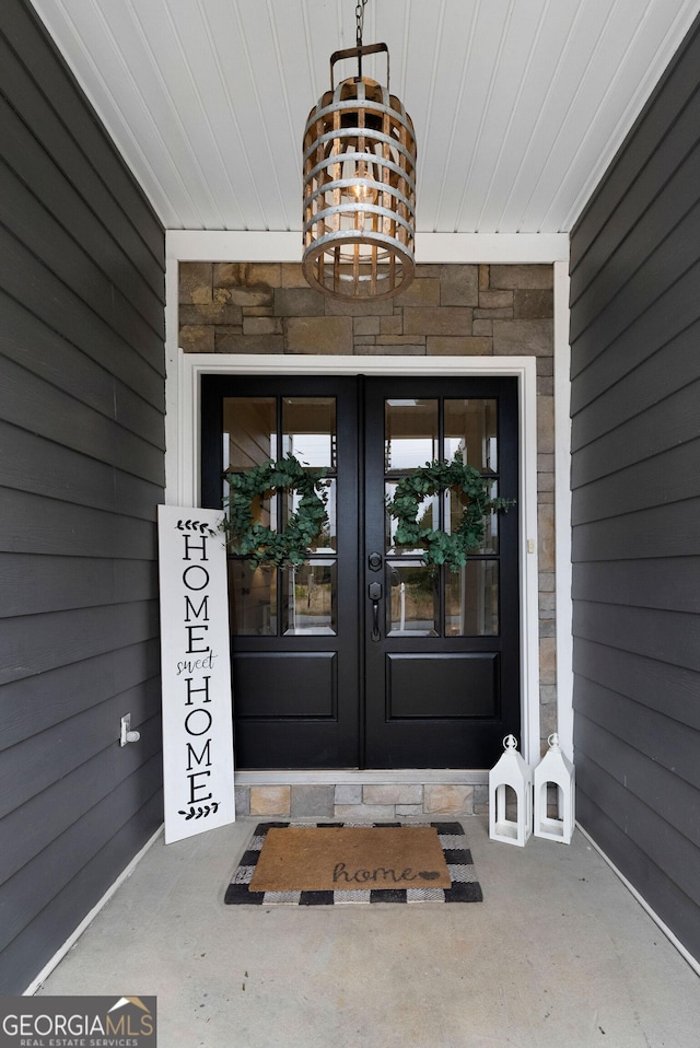 property entrance featuring stone siding and french doors