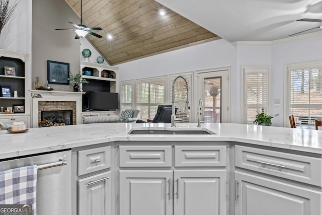 kitchen featuring a ceiling fan, a fireplace, a sink, wood ceiling, and dishwasher