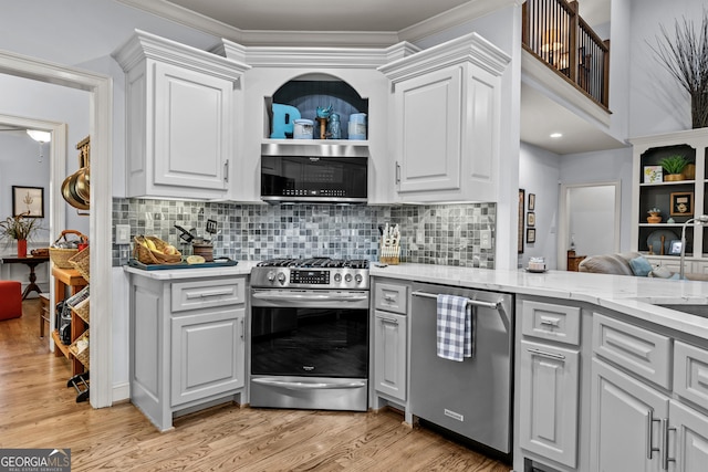 kitchen with white cabinetry, light wood-style floors, tasteful backsplash, and appliances with stainless steel finishes