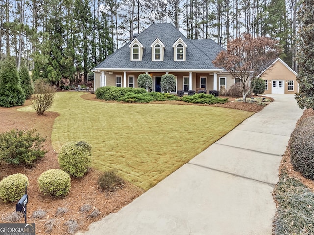 view of front facade with a garage, driveway, roof with shingles, and a front lawn