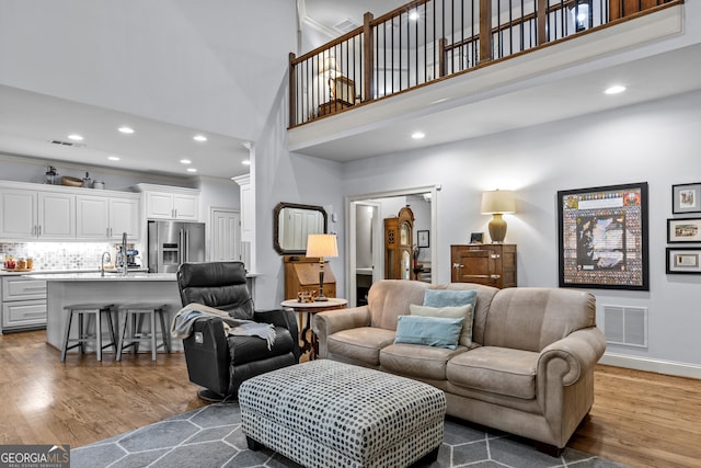 living room featuring wood finished floors, visible vents, and baseboards