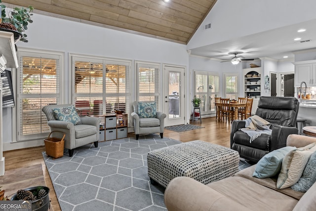 living area featuring visible vents, high vaulted ceiling, ceiling fan, and wood finished floors